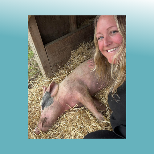 Stephanie Gordon with a pig laying in hay